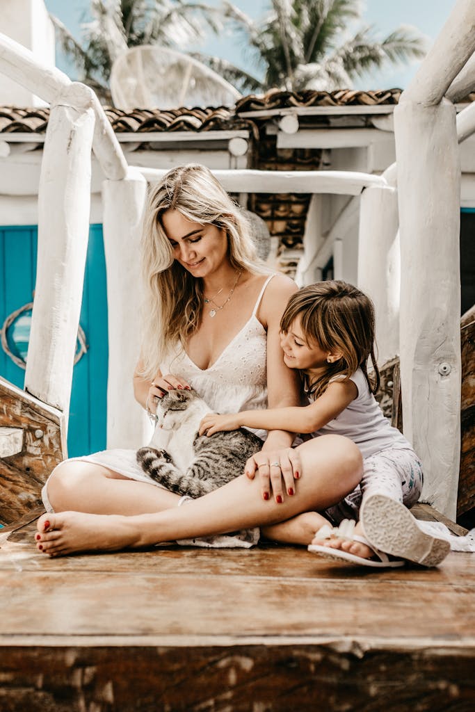 Startseite 7 Startseite A joyful moment between a mother, daughter, and their pet cat on a sunny day outdoors.